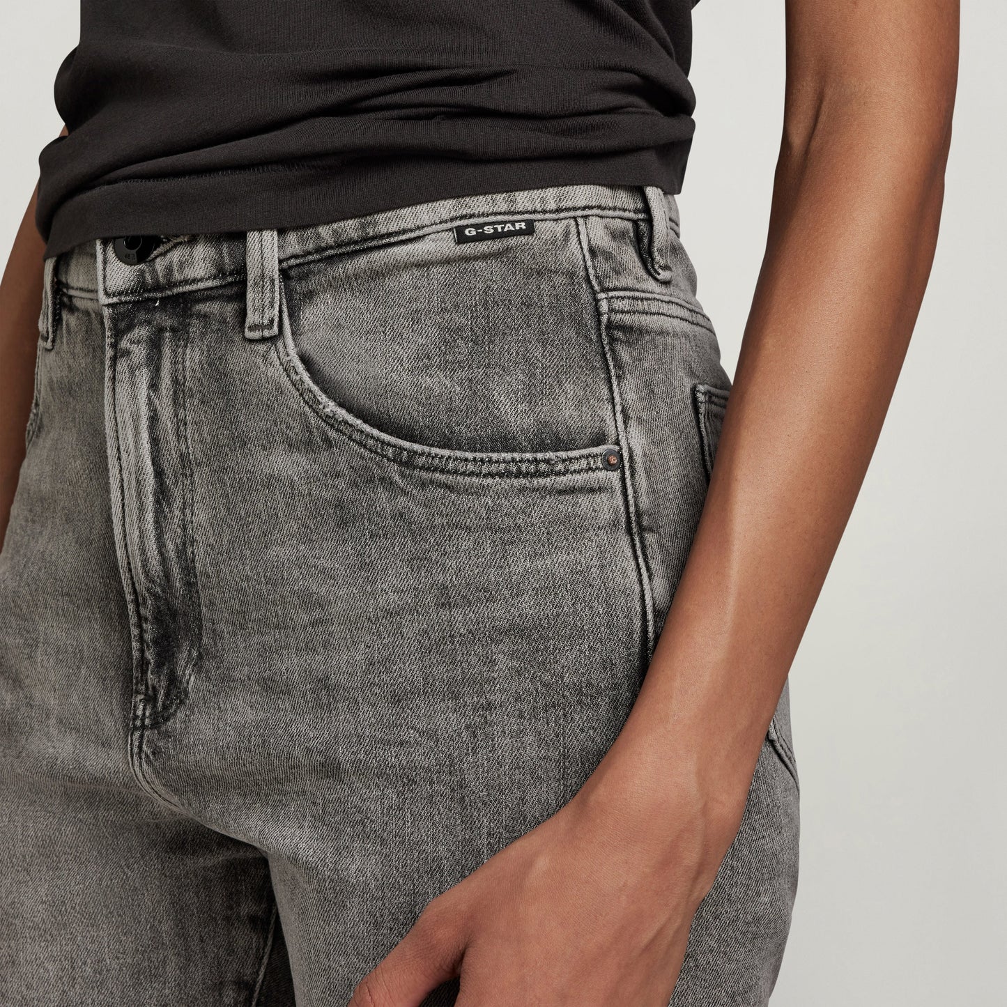 Close-up of high-waisted slim jeans with a stylish fit and unique wash, perfect for any occasion.