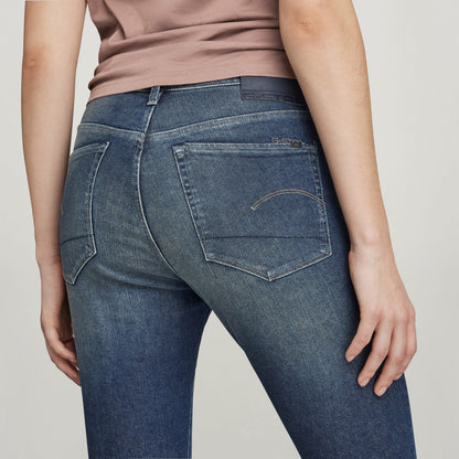 Mujer luciendo jeans 3301 skinny slit, vista trasera enfocando detalles de los bolsillos y corte ajustado.