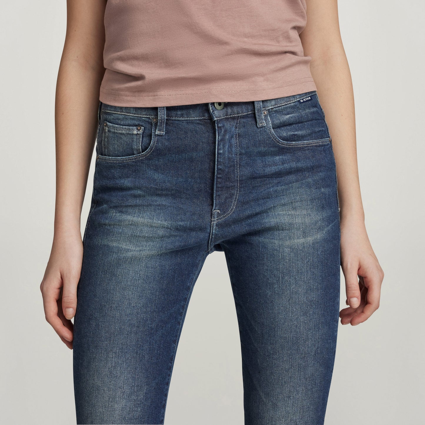Mujer usando skinny slit jeans de corte pitillo, con un top rosa, luciendo un estilo moderno y elegante.