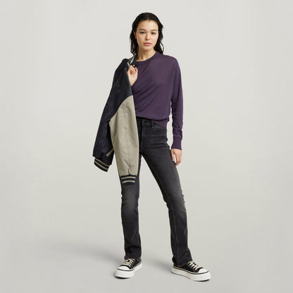 Mujer con jeans Noxer Bootcut y chaqueta, destacando estilo moderno y comodidad, ideal para jugadas casuales. Bootcut jeans for women.