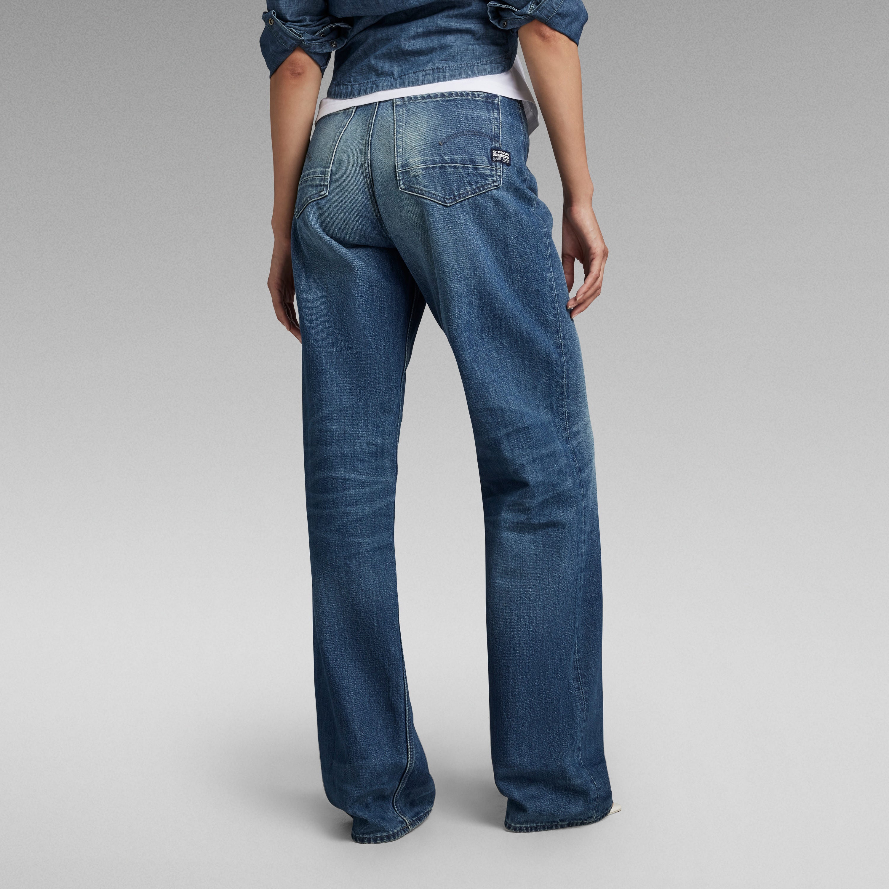 Mujer de espaldas usando jeans Stray Ultra High Loose en denim azul.