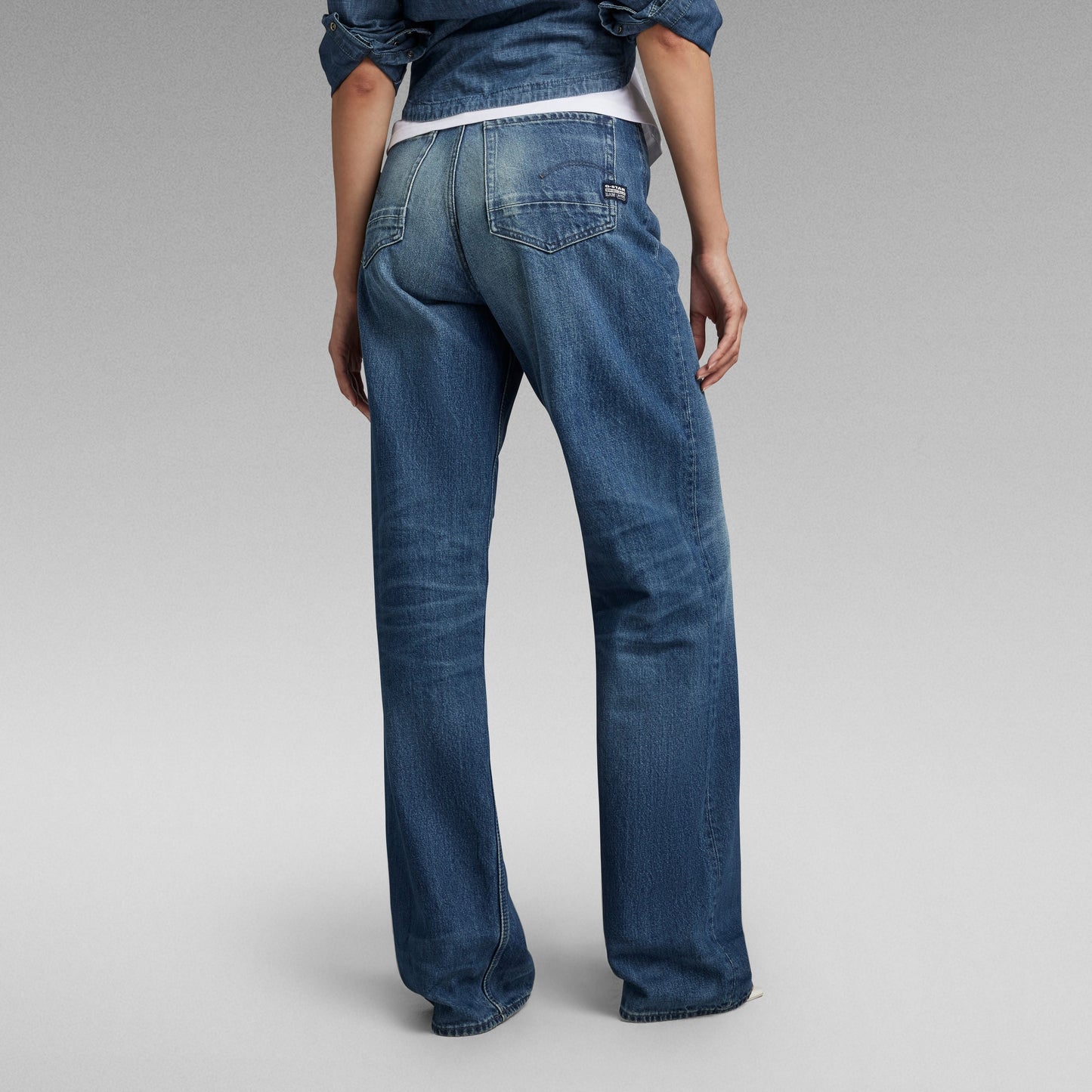 Mujer de espaldas usando jeans Stray Ultra High Loose en denim azul.