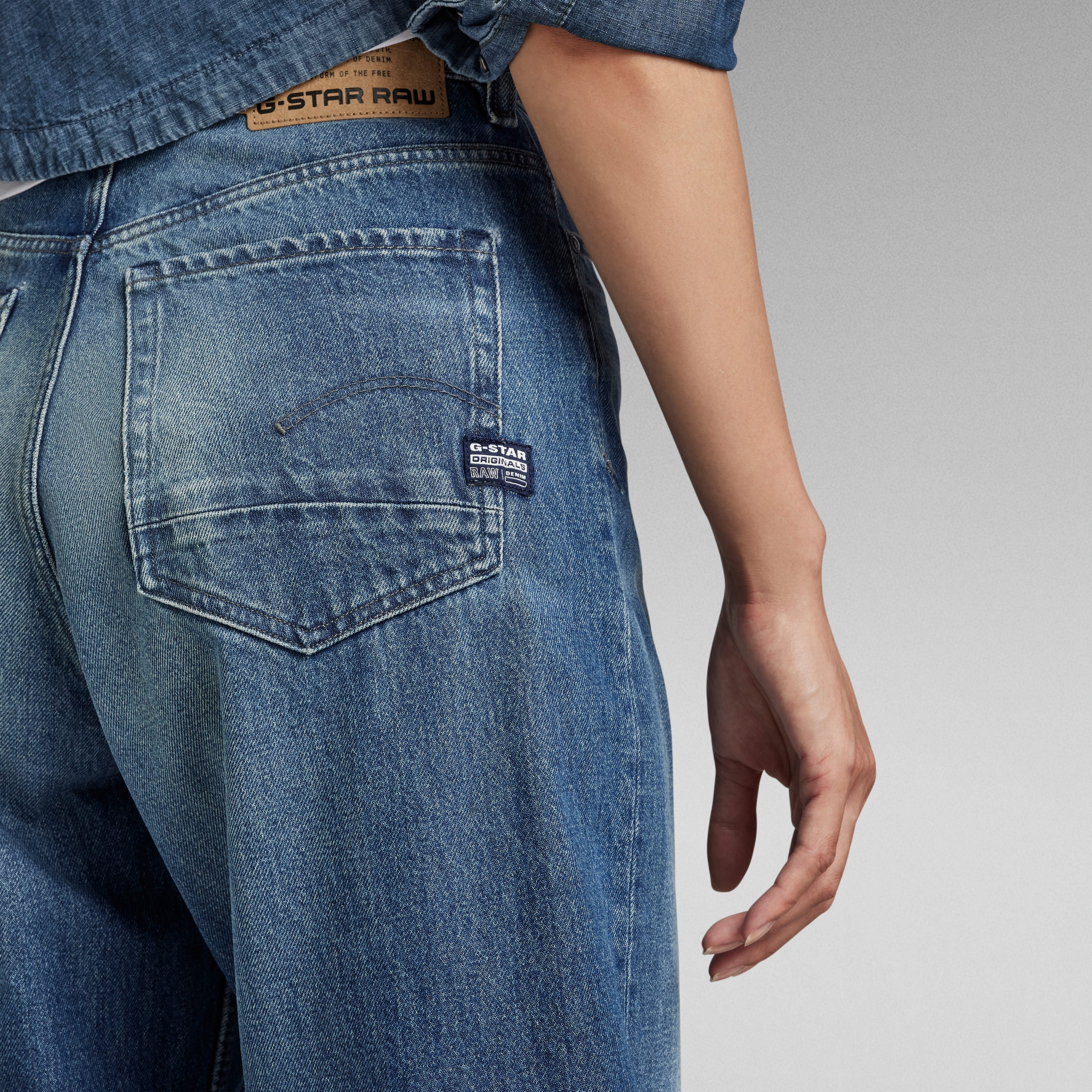 Mujer usando jeans Stray Ultra High Loose de G-Star RAW, con detalles de bolsillo trasero.