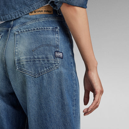Mujer usando jeans Stray Ultra High Loose de G-Star RAW, con detalles de bolsillo trasero.