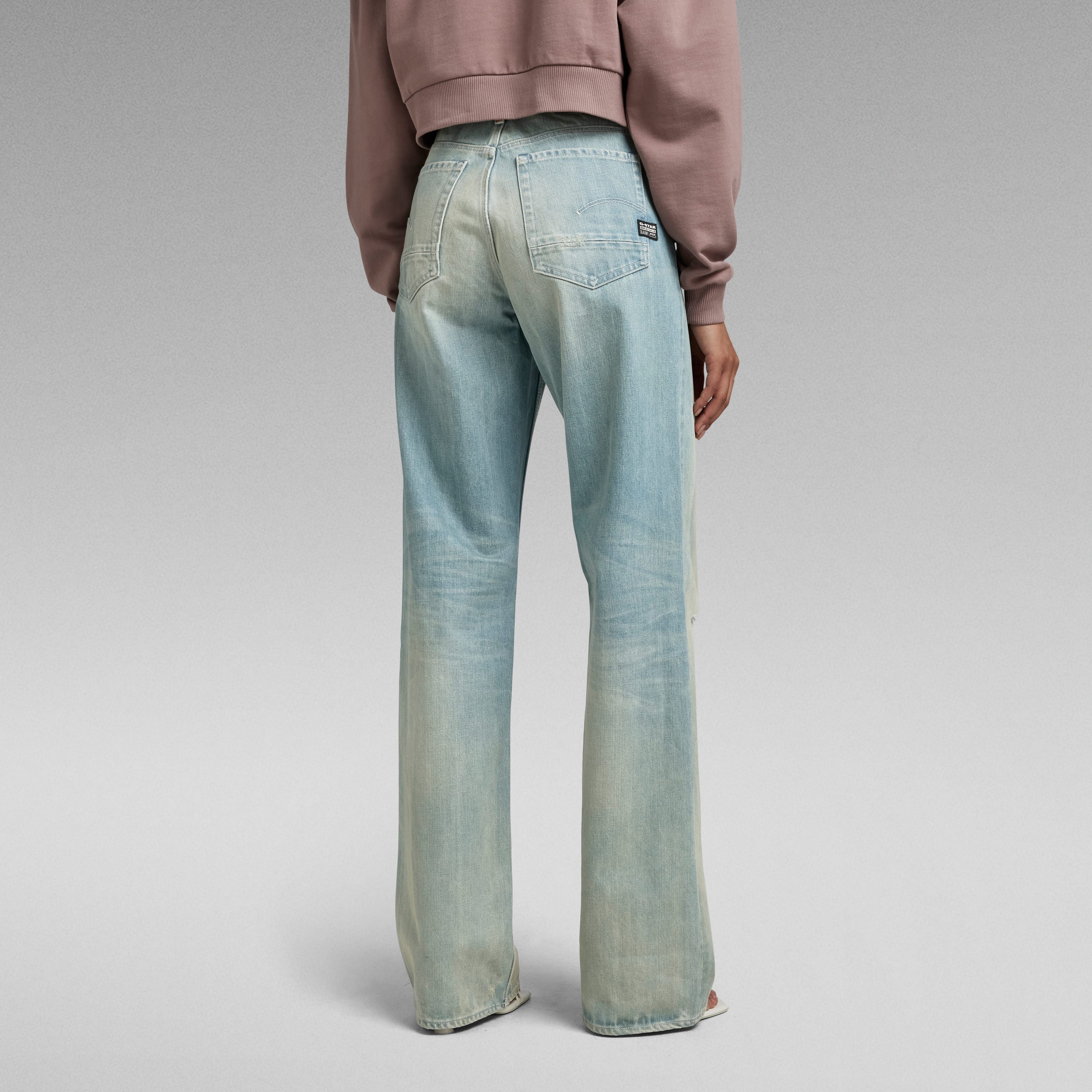 Mujer usando jeans Stray Ultra High Loose desde atrás, mostrando el diseño de corte holgado y talle muy alto.