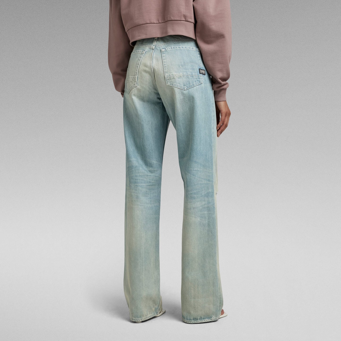Mujer usando jeans Stray Ultra High Loose desde atrás, mostrando el diseño de corte holgado y talle muy alto.