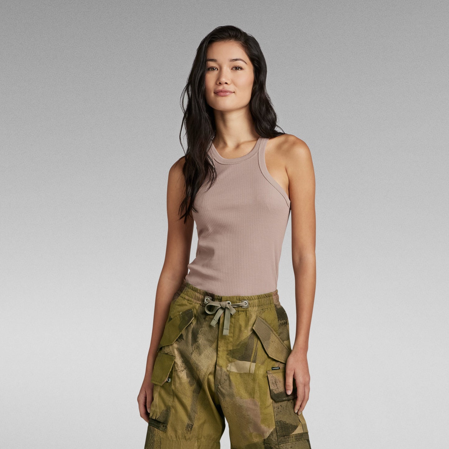 Mujer usando camiseta sin mangas Italian Army Ultra Slim de G-Star RAW en color nude con pantalones verdes.