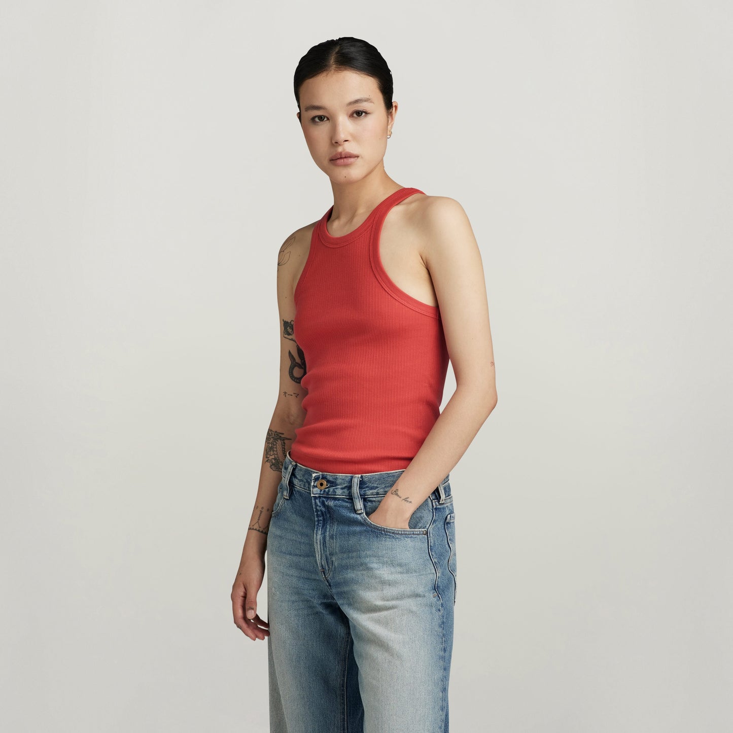 Modelo usando camisetas sin mangas Italian Army ultra slim de G-Star RAW en color rojo con jeans azules.