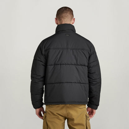 Hombre de espaldas usando la chaqueta acolchada impermeable Foundation, mostrando su diseño acolchado y cómodo.