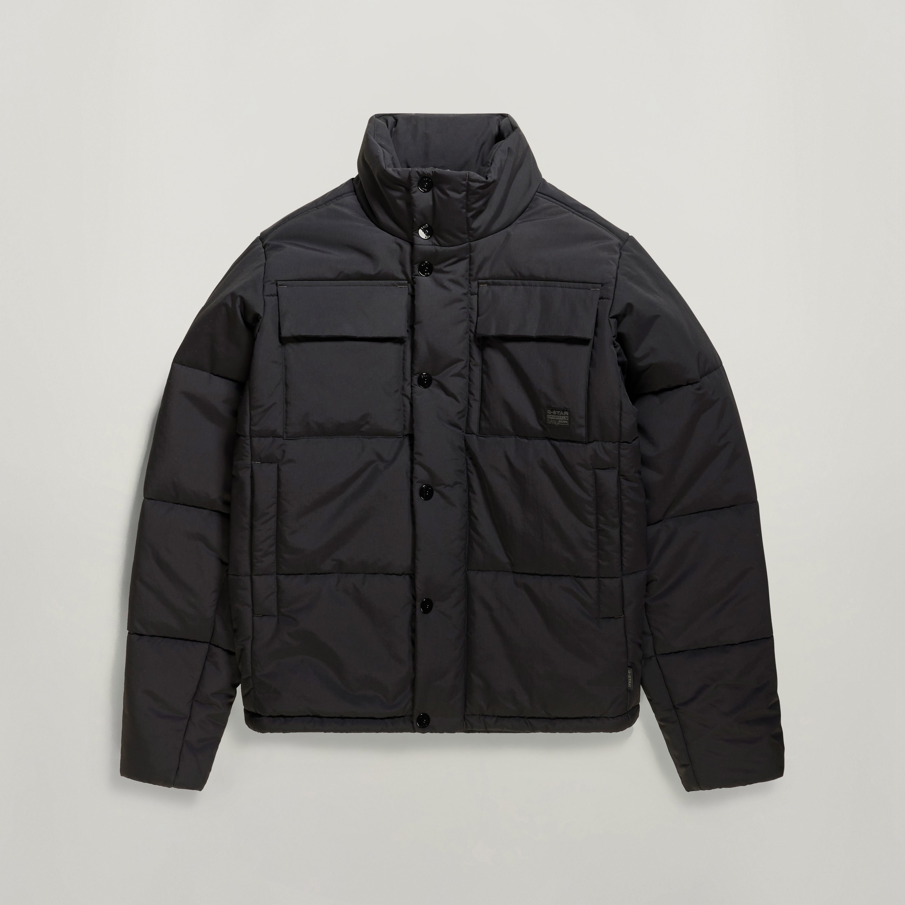 Chaqueta acolchada impermeable Foundation en color negro con cuello alzado y bolsillos frontales.