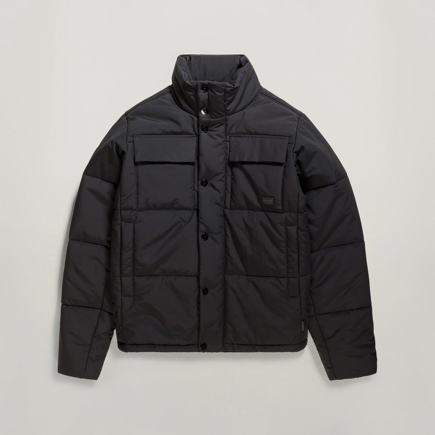 Chaqueta acolchada impermeable Foundation en color negro con cuello alzado y bolsillos frontales.