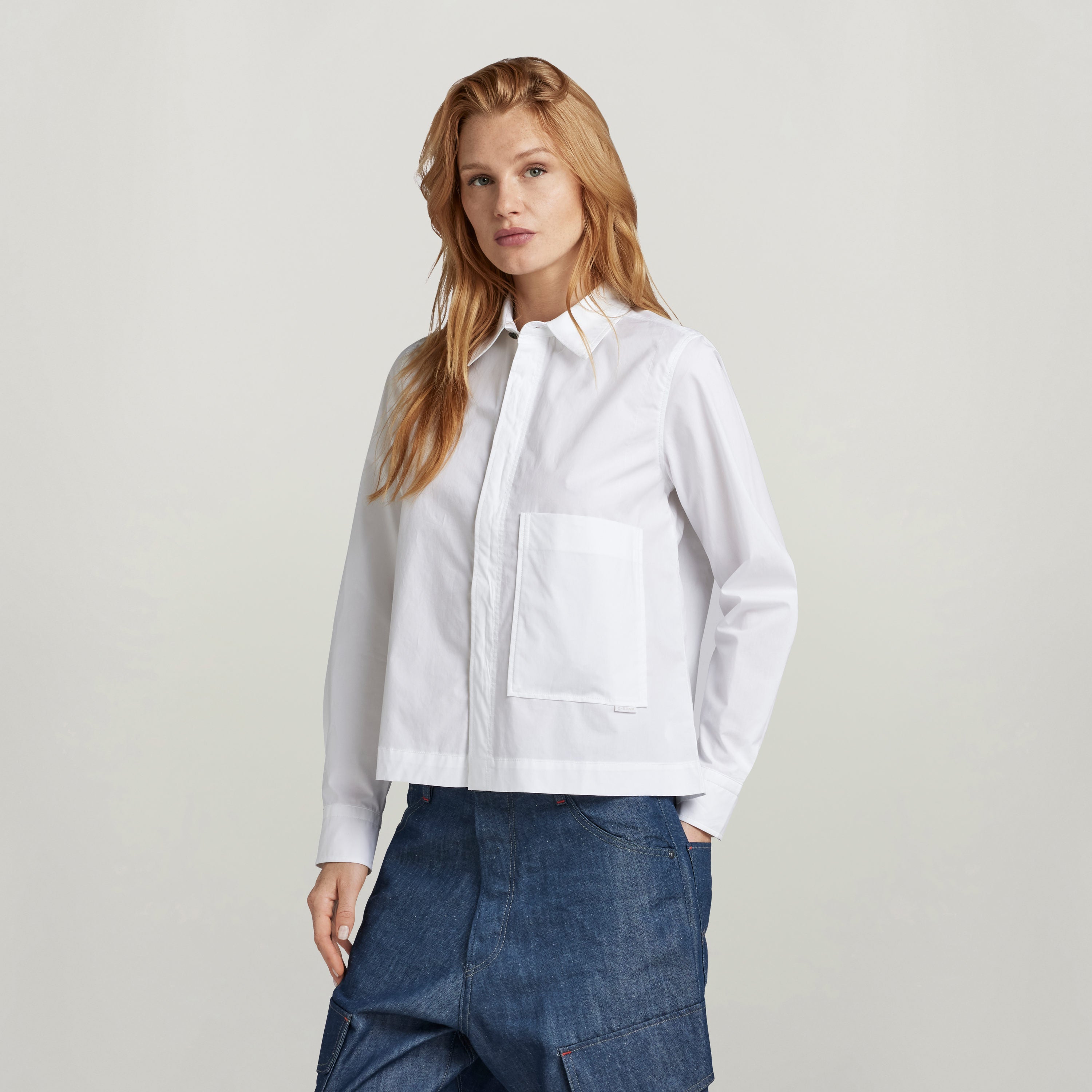 Camisa boxy manga larga G Star, blanca, con bolsillos en el pecho y cierre oculto, diseño moderno y casual.