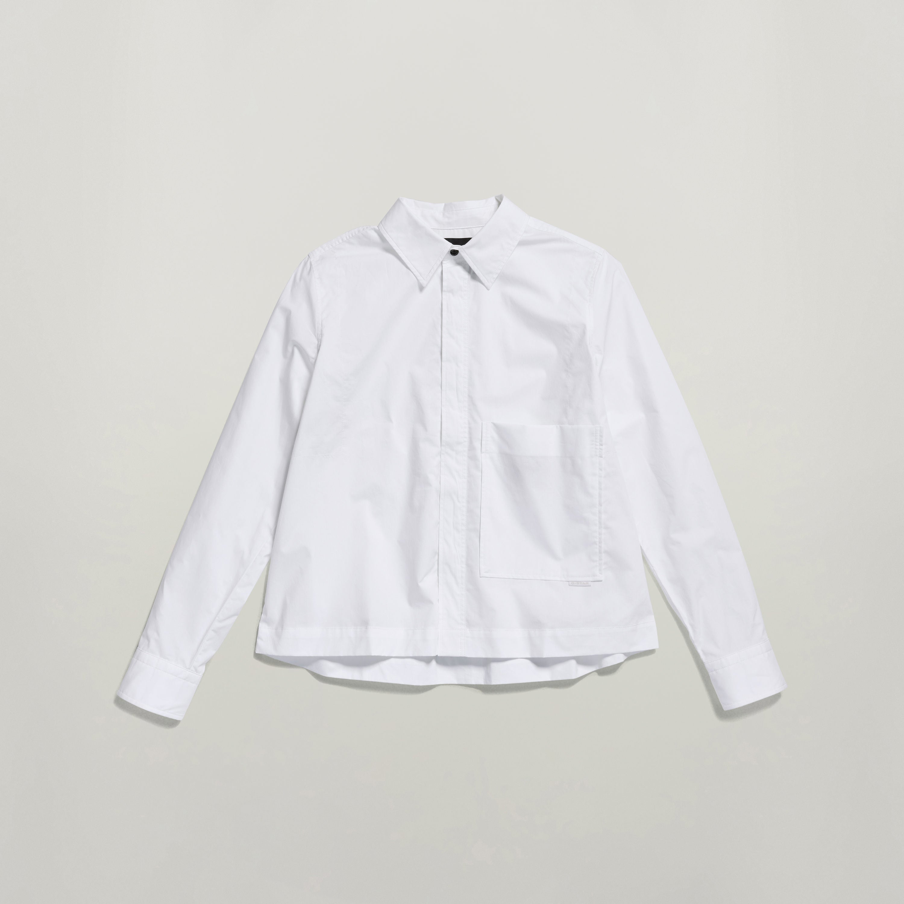 Camisa boxy manga larga G Star en color blanco, con bolsillos en el pecho y cierre oculto.