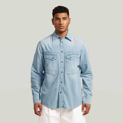 Camisa de manga larga Dakota en denim azul claro con cierre de botones y cuello clásico, modelo masculino.