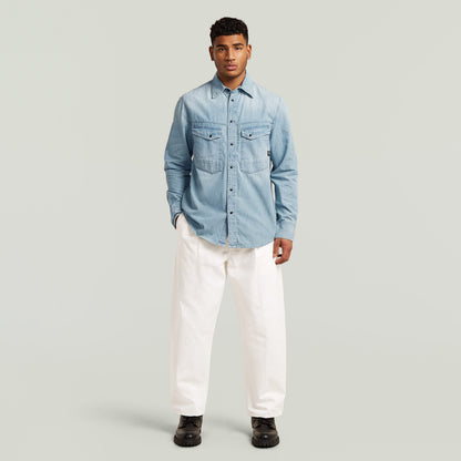 Camisa de manga larga Dakota en denim claro con cuello clásico y cierre de botones, modelo masculino.