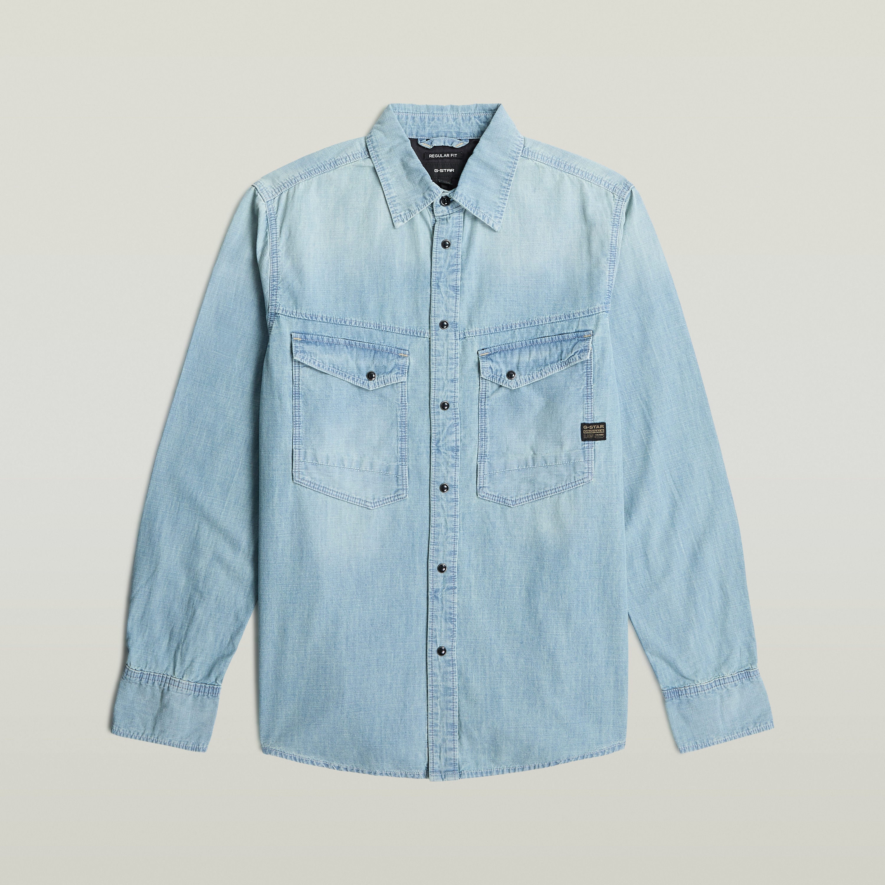 Camisa de manga larga Dakota en denim ligero color azul claro con botones a presión y diseño de corte recto.