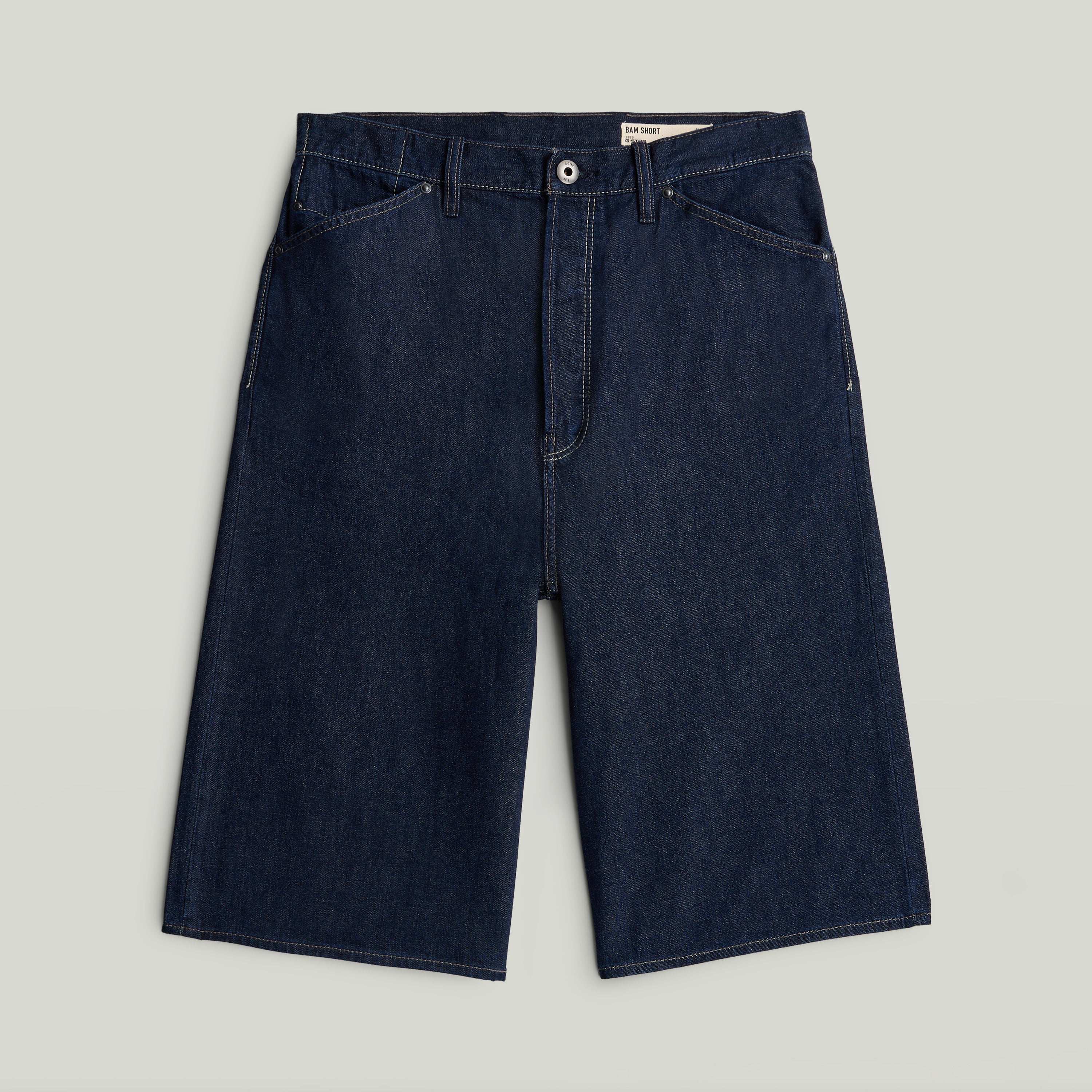 relaxed fit jorts in dark blue denim with classic button closure and five pockets.