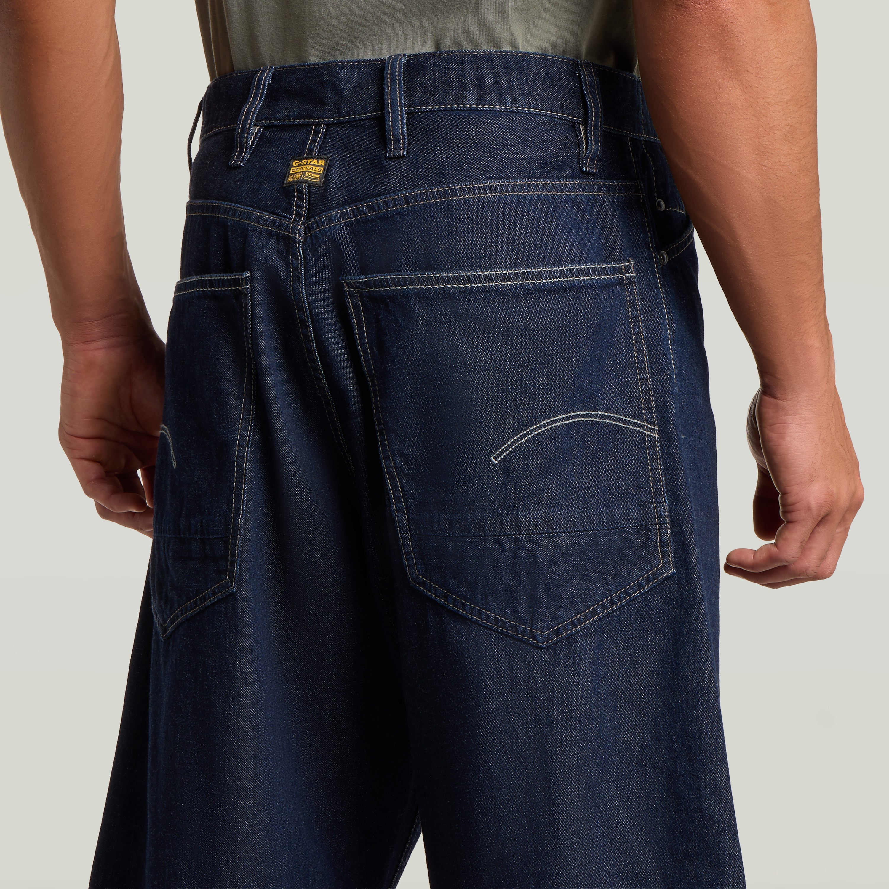 Vista trasera de los jorts de corte relajado con acordeón y etiqueta G-Star Originals en azul oscuro.