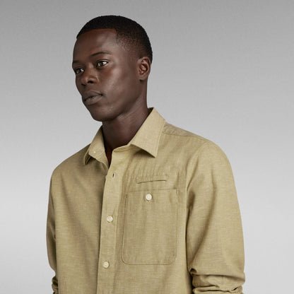 Modelo usando la camisa bristum 2.0 slim en color beige con detalles en el bolsillo y cuello.