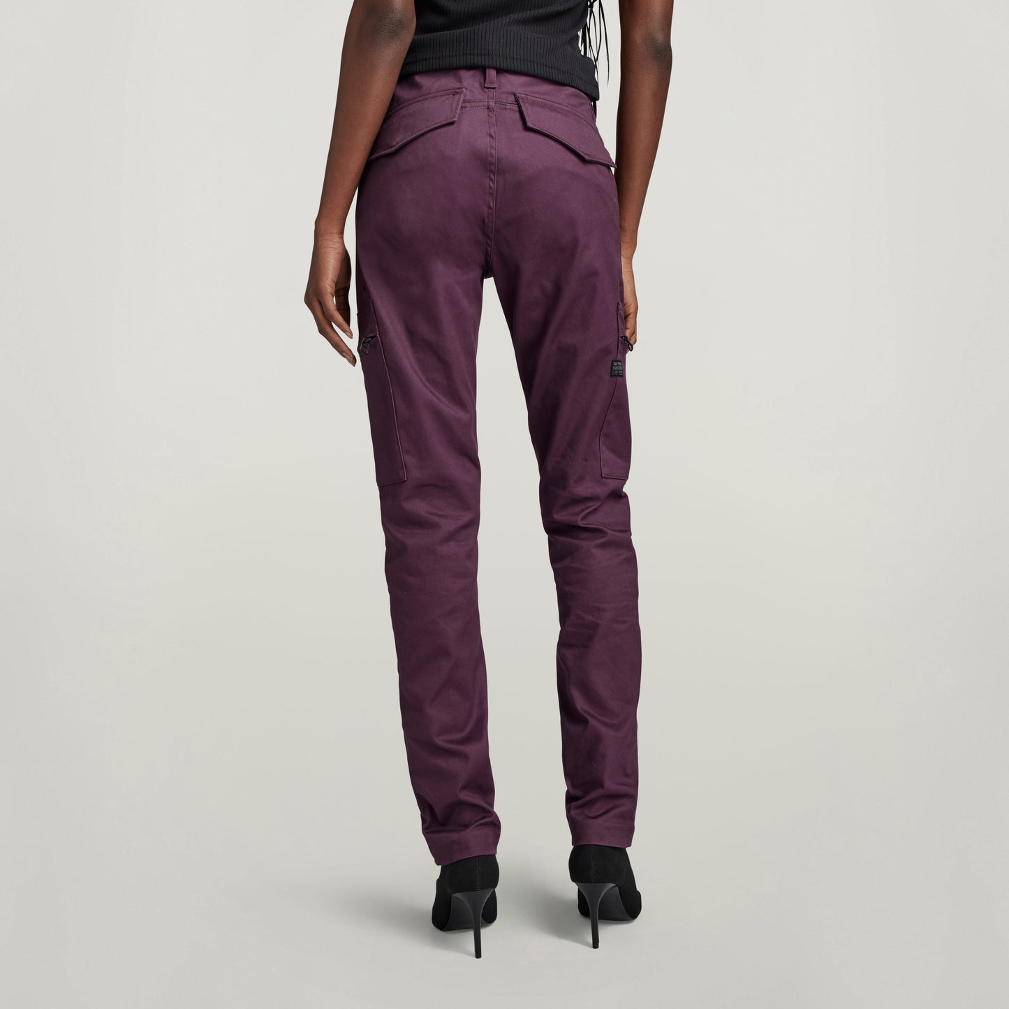 Mujer usando pantalones Slim Cargo ajustados en color púrpura desde atrás.