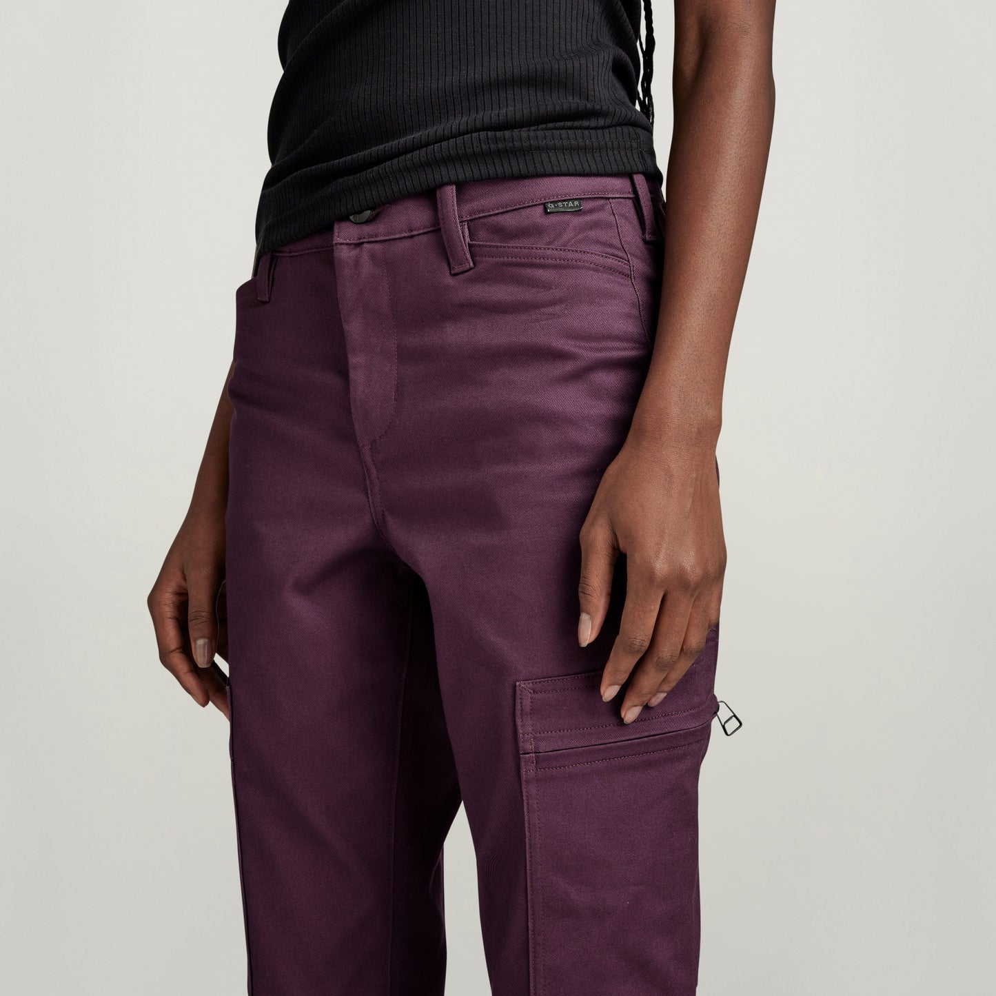 Pantalones Slim Cargo de ajuste ajustado en color púrpura con bolsillos con cremallera oculta.