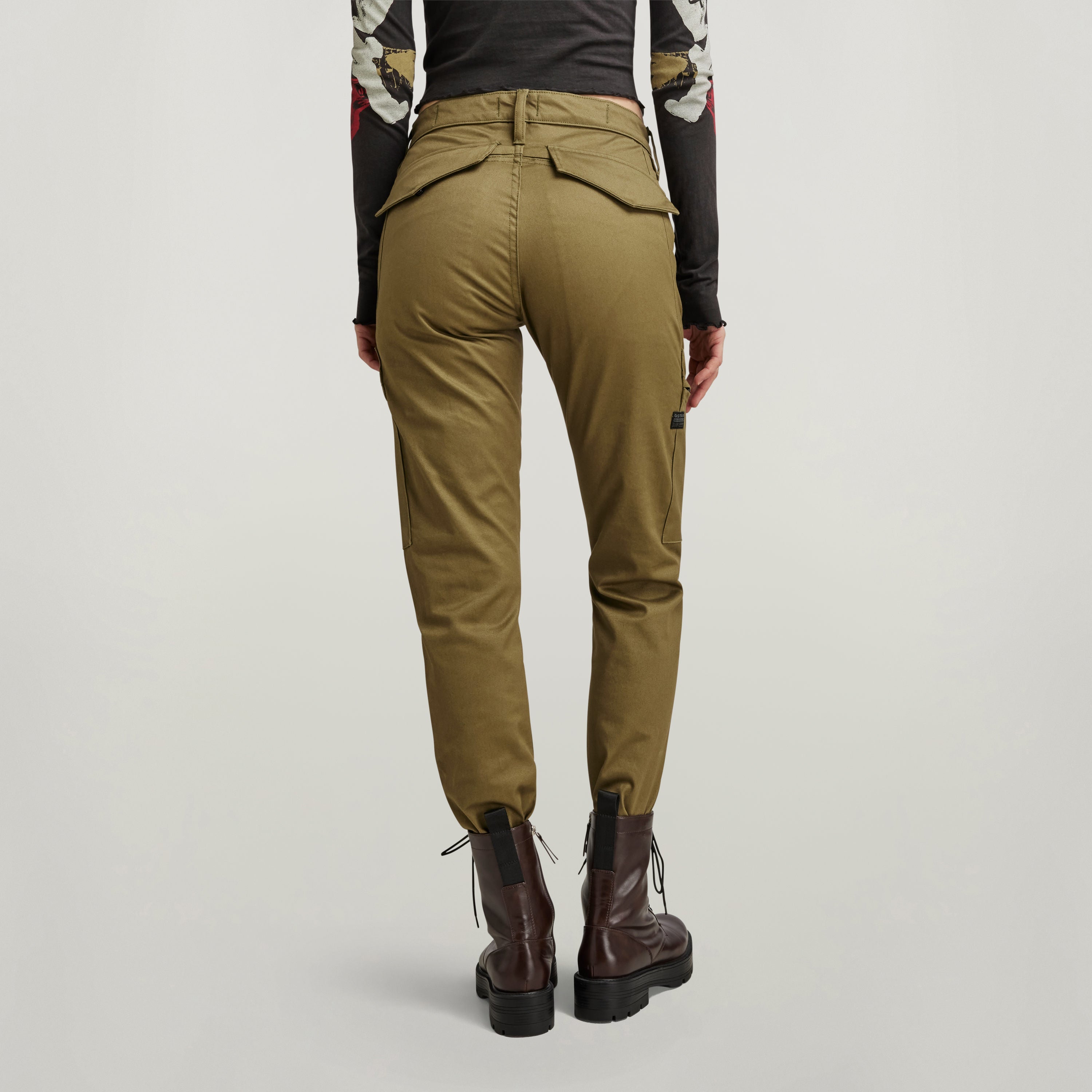 Vista trasera de pantalones slim cargo con bolsillos en color oliva, mostrando su diseño ajustado y estilo moderno.