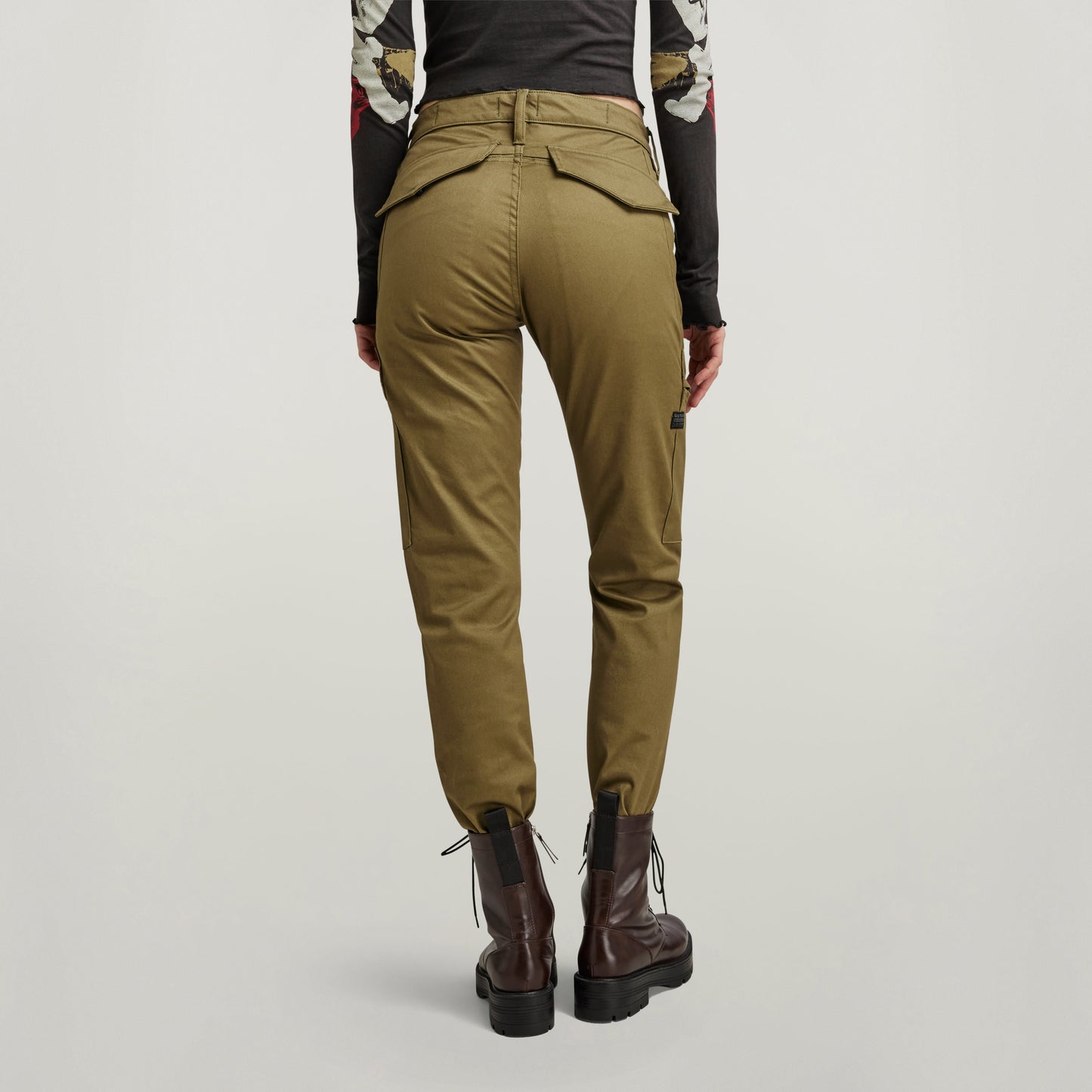 Vista trasera de pantalones slim cargo con bolsillos en color oliva, mostrando su diseño ajustado y estilo moderno.