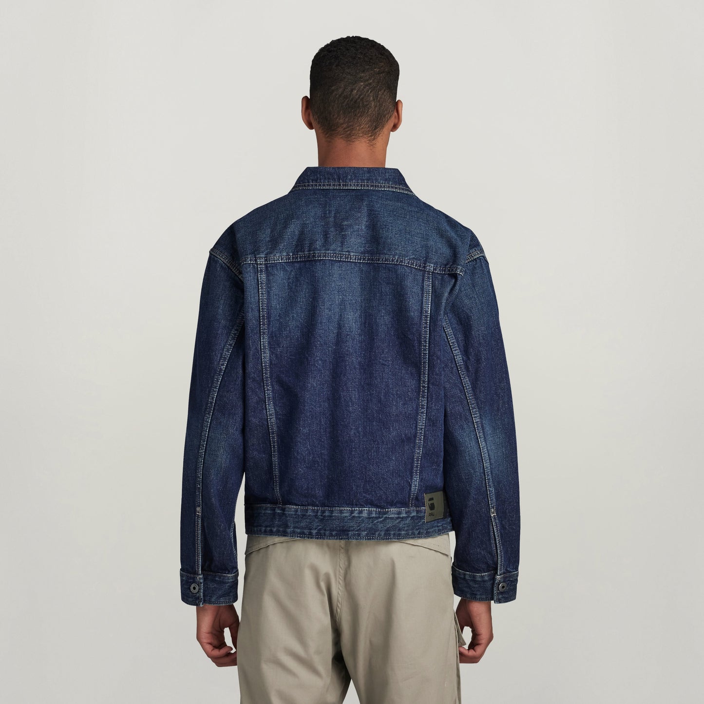 Vista trasera de la chaqueta denim Dakota en un modelo masculino, mostrando diseño clásico y corte recto.