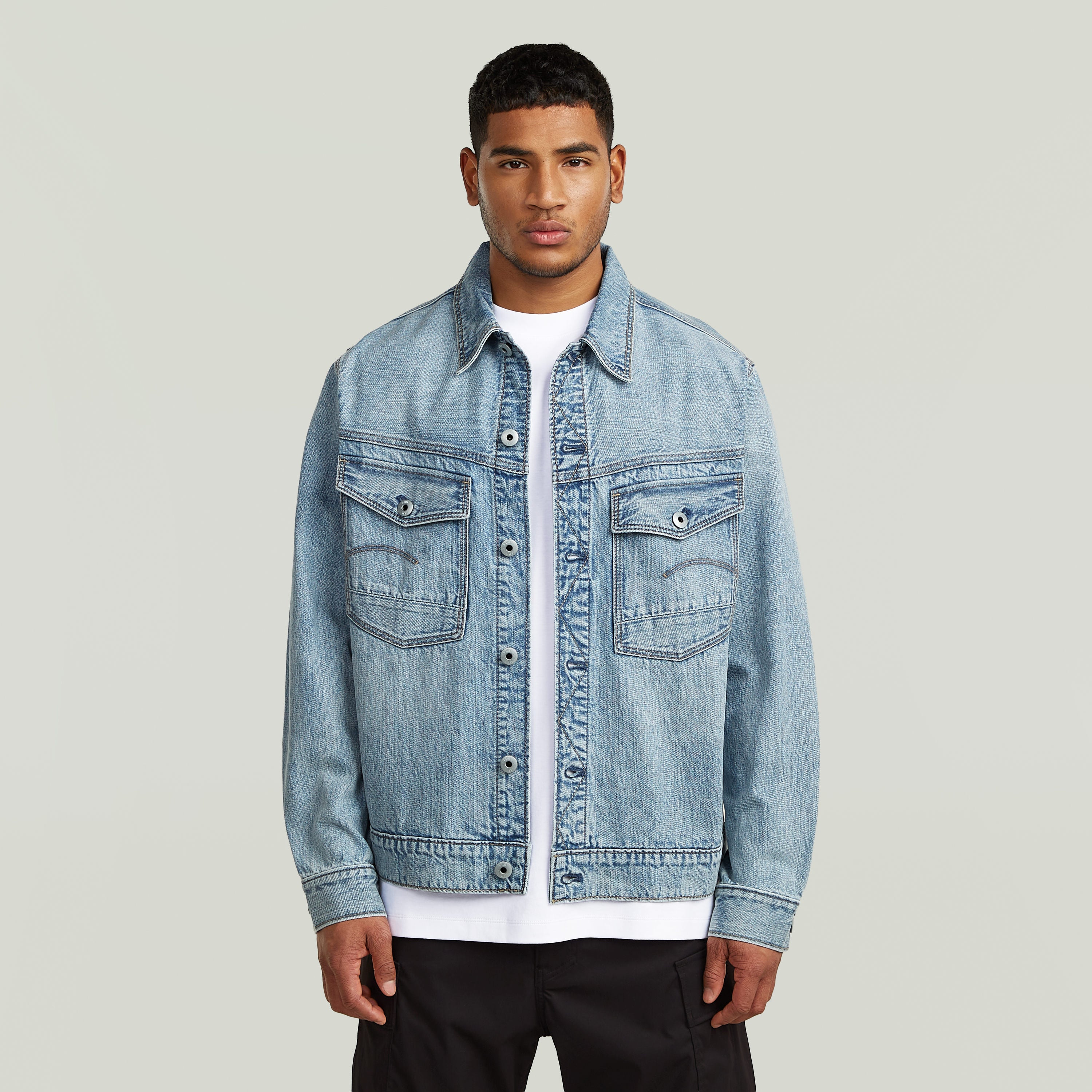 Chaqueta denim Dakota con corte recto, bolsillos en el pecho y cierre de botones, modelo en fondo claro.