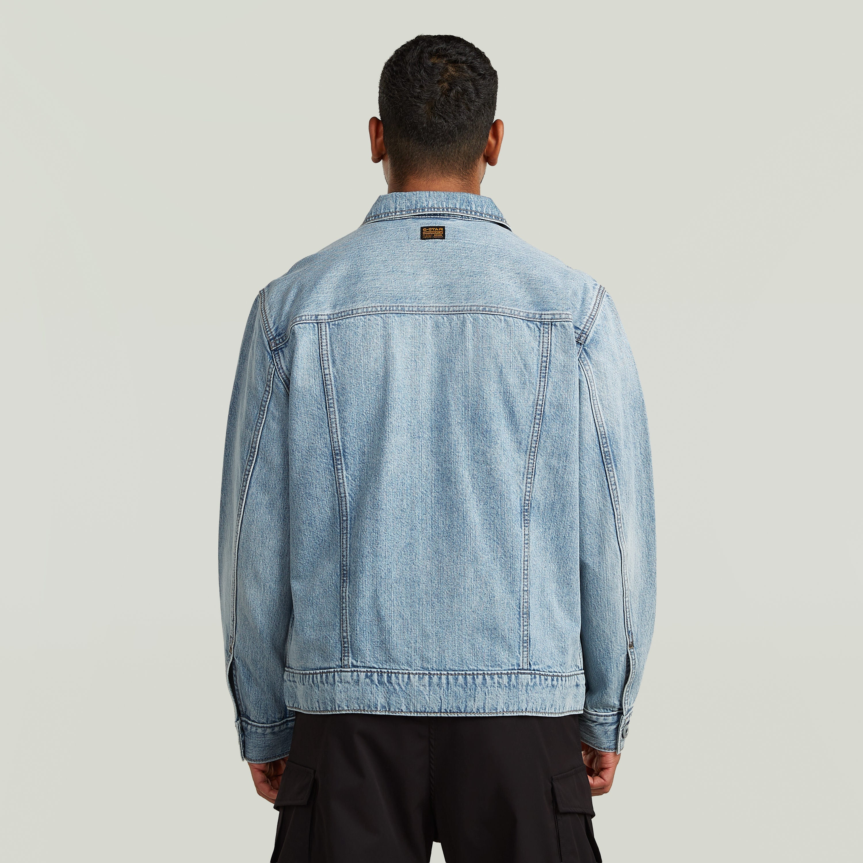 Vista trasera de la chaqueta denim Dakota en un hombre, resaltando el diseño clásico y moderno.