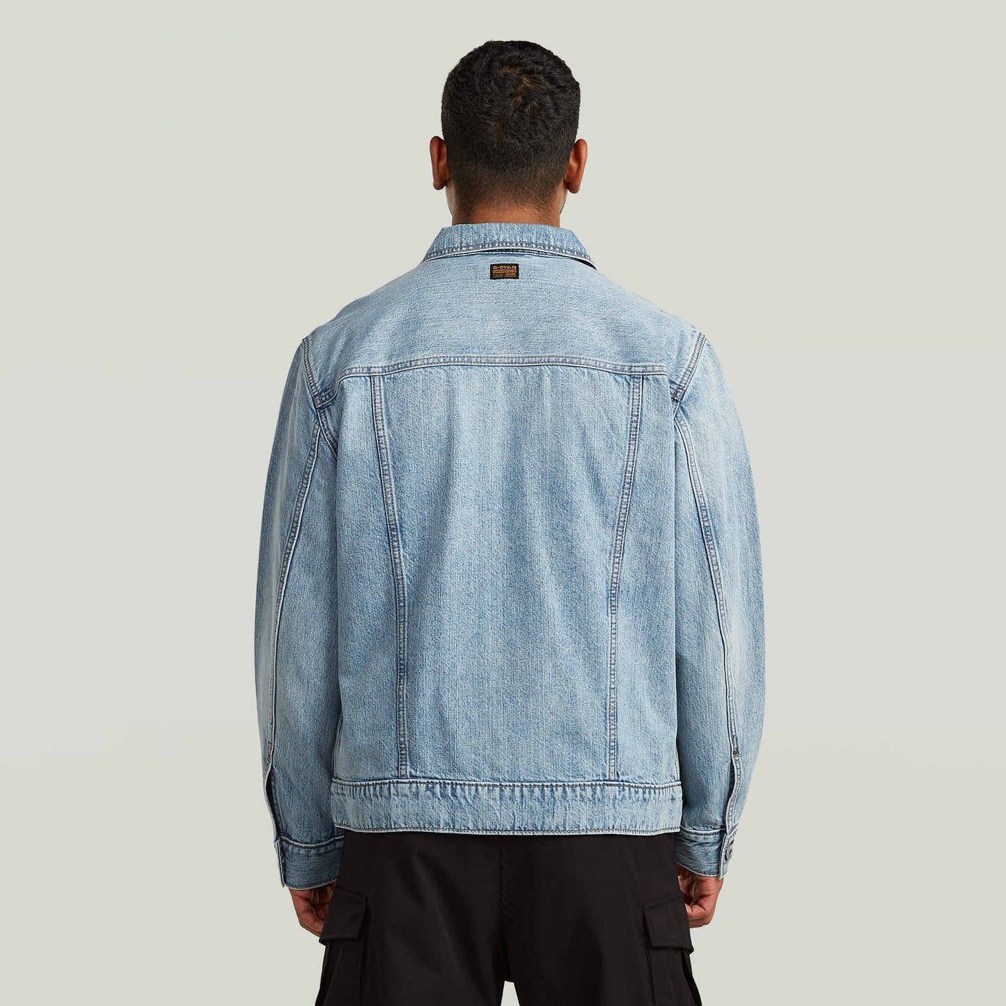 Vista trasera de la chaqueta denim Dakota en un hombre, resaltando el diseño clásico y moderno.