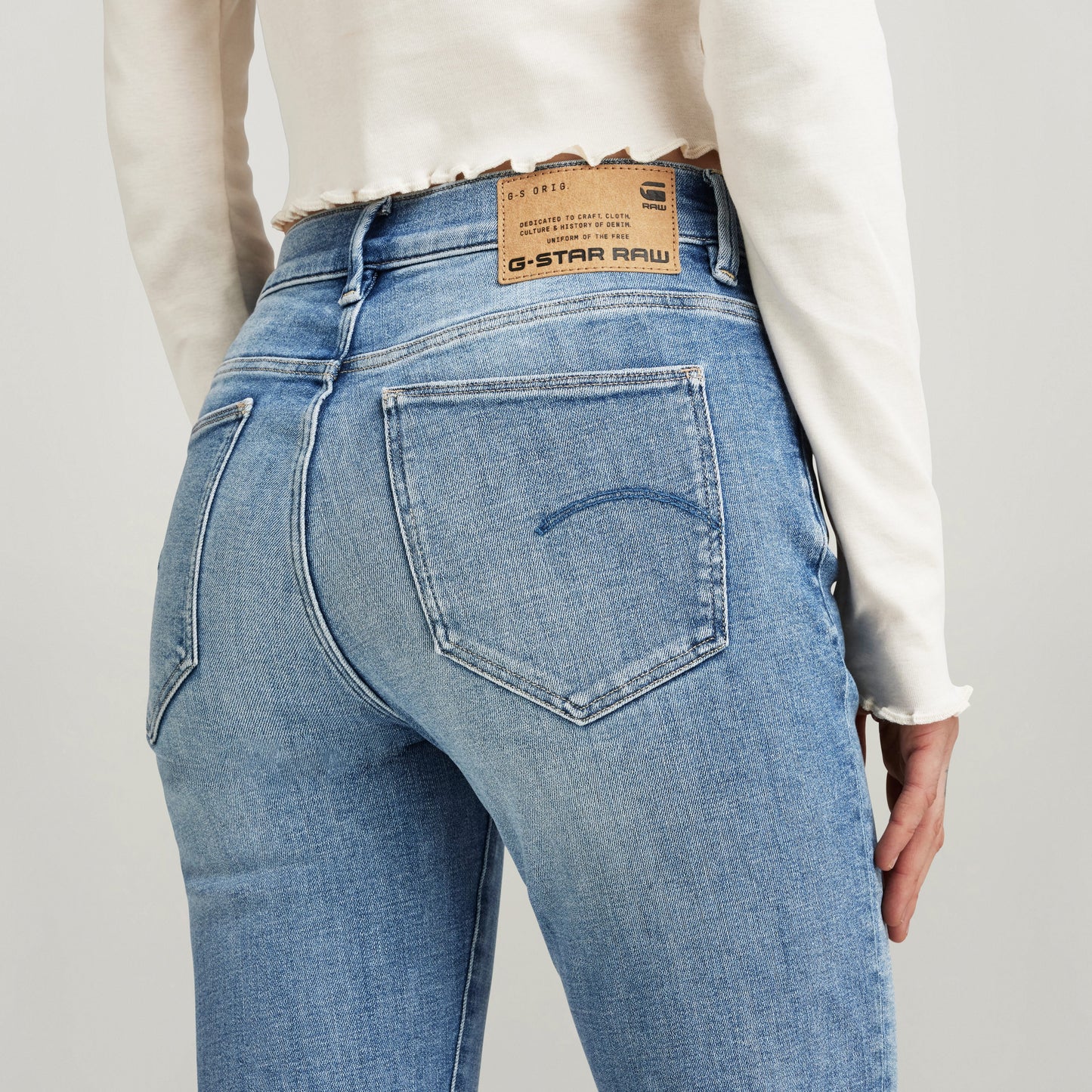 Mujer usando jeans Ace 2.0 de G-Star Raw, vista trasera mostrando bolsillos y etiqueta, slim straight jeans for men.