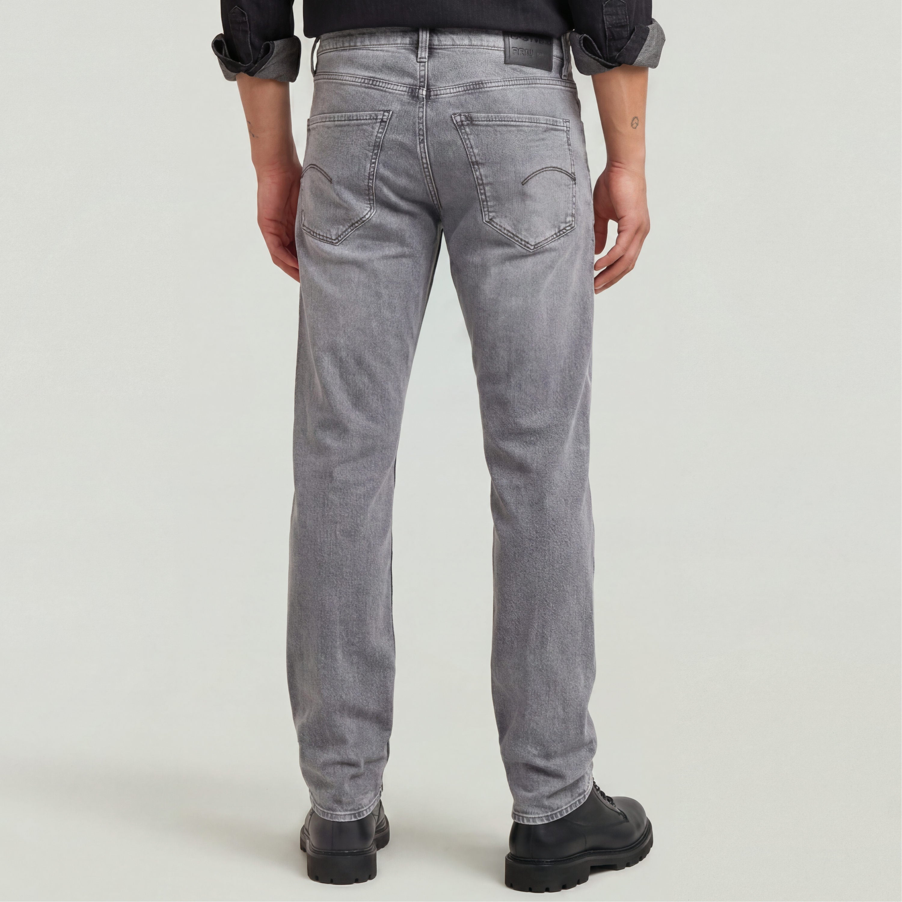 Hombre vistiendo Mosa straight jeans, vista trasera, diseño clásico con ajuste medio y pierna estrecha en color gris.