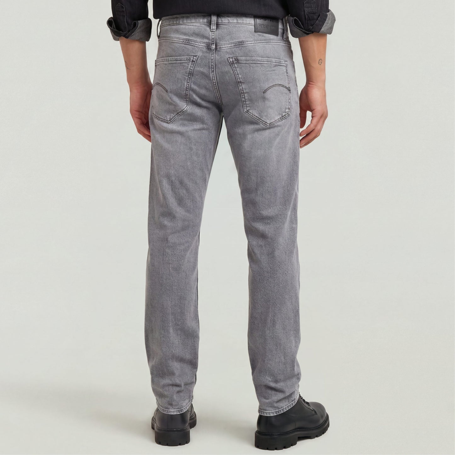 Hombre vistiendo Mosa straight jeans, vista trasera, diseño clásico con ajuste medio y pierna estrecha en color gris.