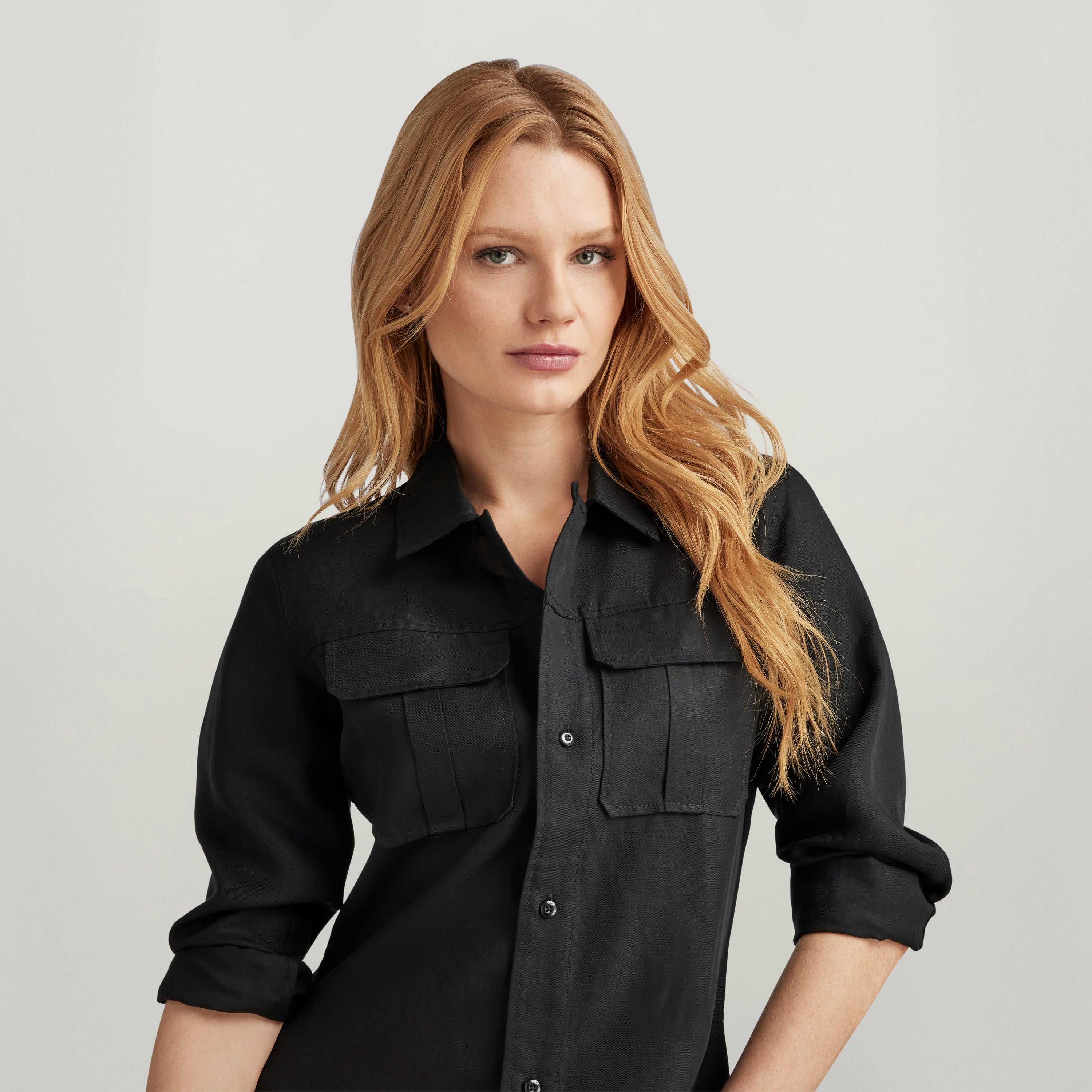 Camisa fitted officer con bolsillos, negra, de manga larga, con solapas y cierre oculto, modelo femenino.