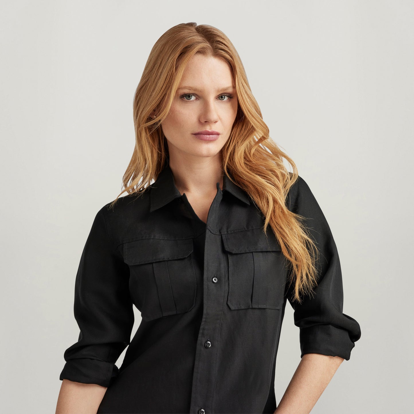 Camisa fitted officer con bolsillos, negra, de manga larga, con solapas y cierre oculto, modelo femenino.