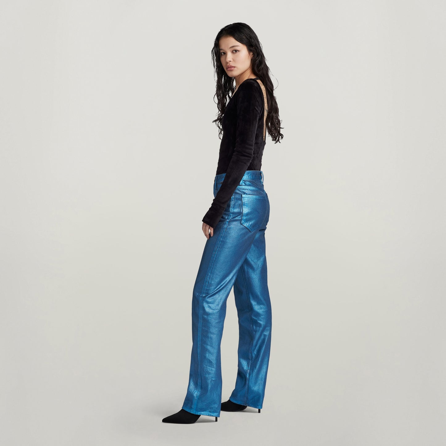 Modelo vistiendo jeans Viktoria de talle alto y corte recto en color azul brillante, de perfil.