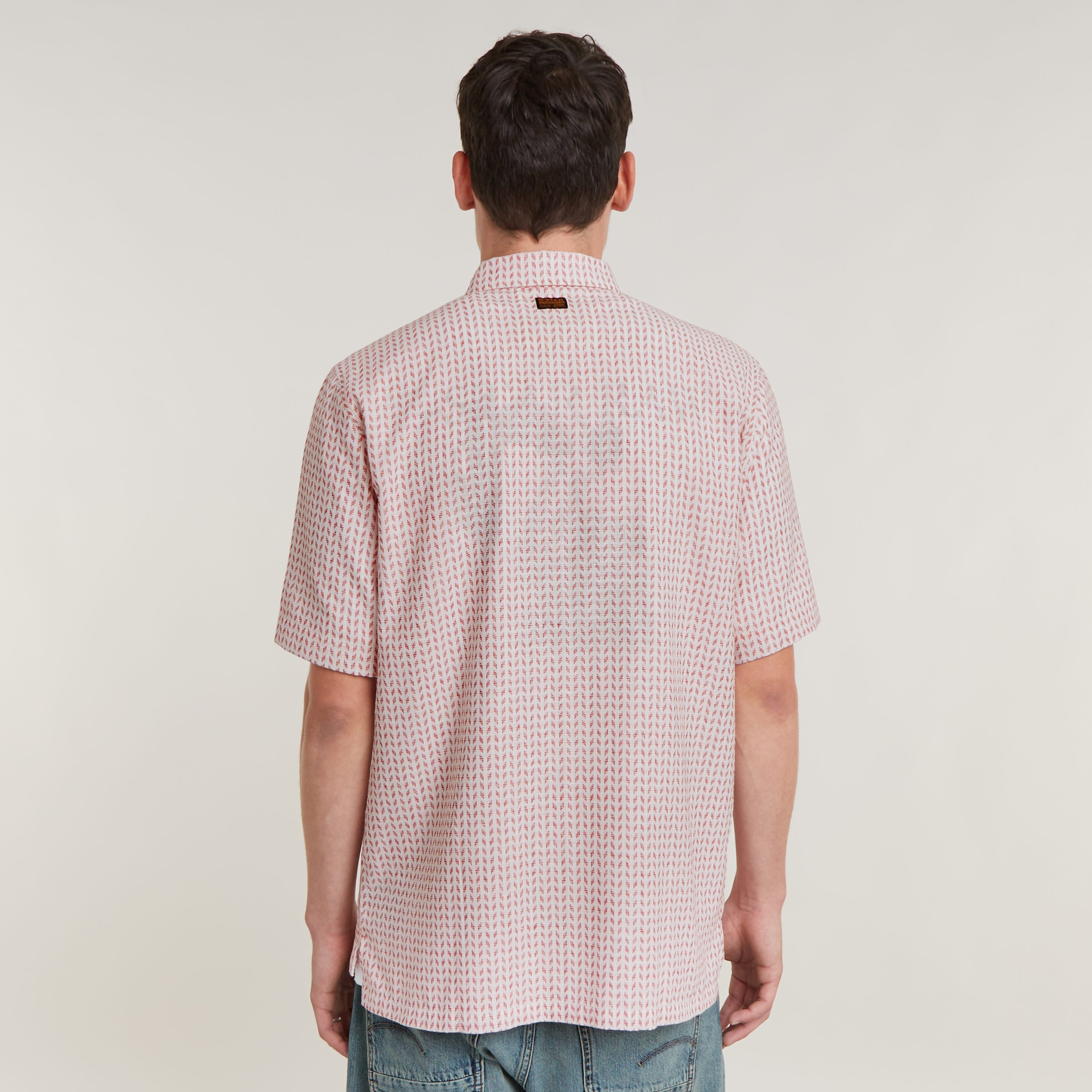 Camisa Resort de corte recto vista trasera con cuello plano y diseño ligero en color rosa.