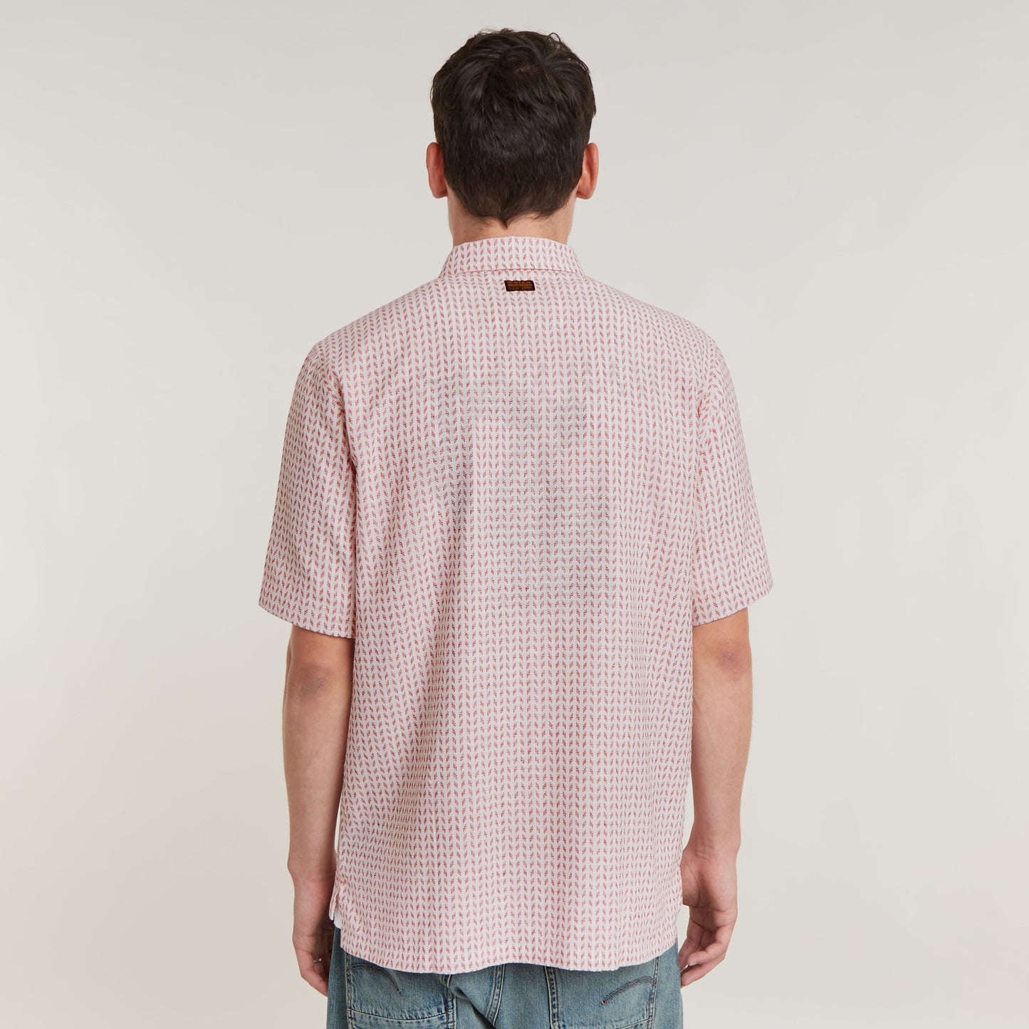 Camisa Resort de corte recto vista trasera con cuello plano y diseño ligero en color rosa.