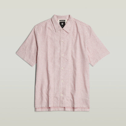 Camisa Resort de corte recto con diseño de estampado en tonos rojo y blanco, botón frontal y cuello plano.