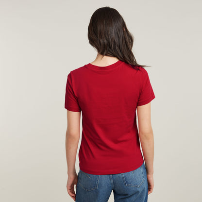 Back view of a woman wearing a red top front seam t-shirt, showcasing its simple design.