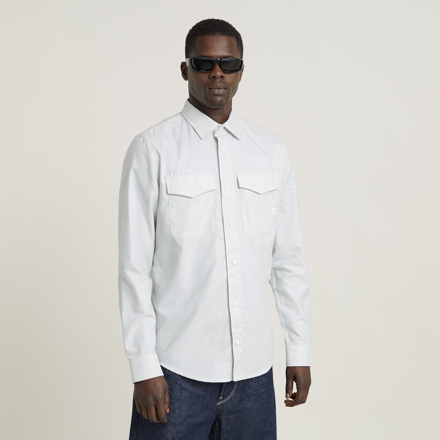 Hombre usando una camisa Marine Slim ajuste de color blanco con puños y bolsillos con solapa.