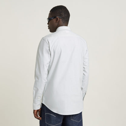 Hombre vistiendo la camisa Marine Slim ajuste de algodón en color claro, vista trasera con detalles en los puños.