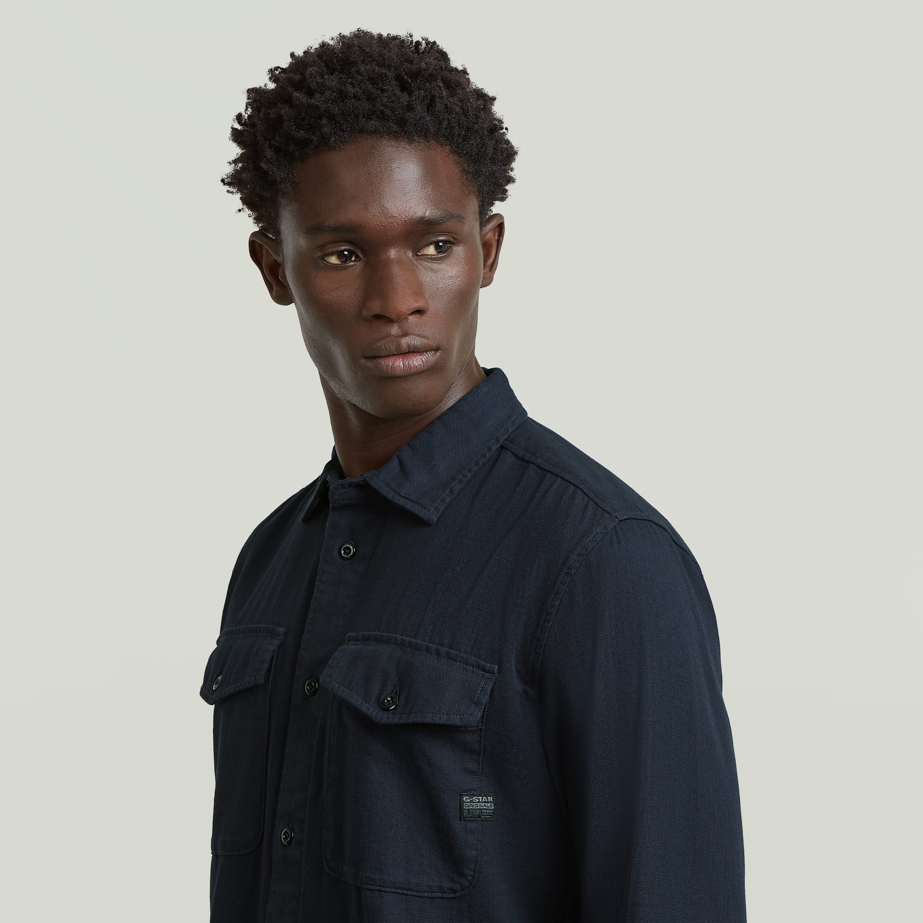 Camisa Marine Slim azul en modelo, corte ajustado, color azul oscuro y detalles de bolsillos en el pecho.