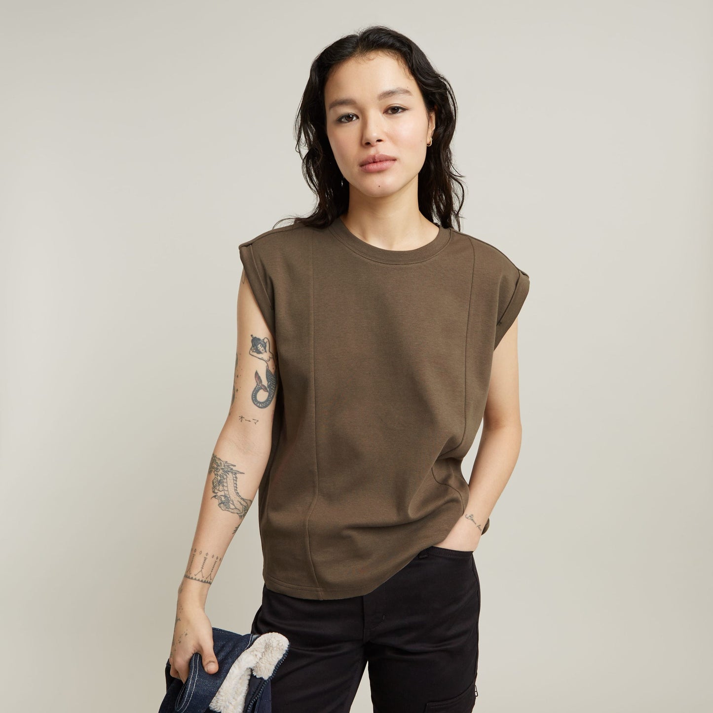 constructed loose top with short sleeves in brown color, featuring shoulder padding and a relaxed fit.