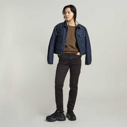 Model wearing a constructed loose top with short sleeves, styled with a denim jacket and black pants.
