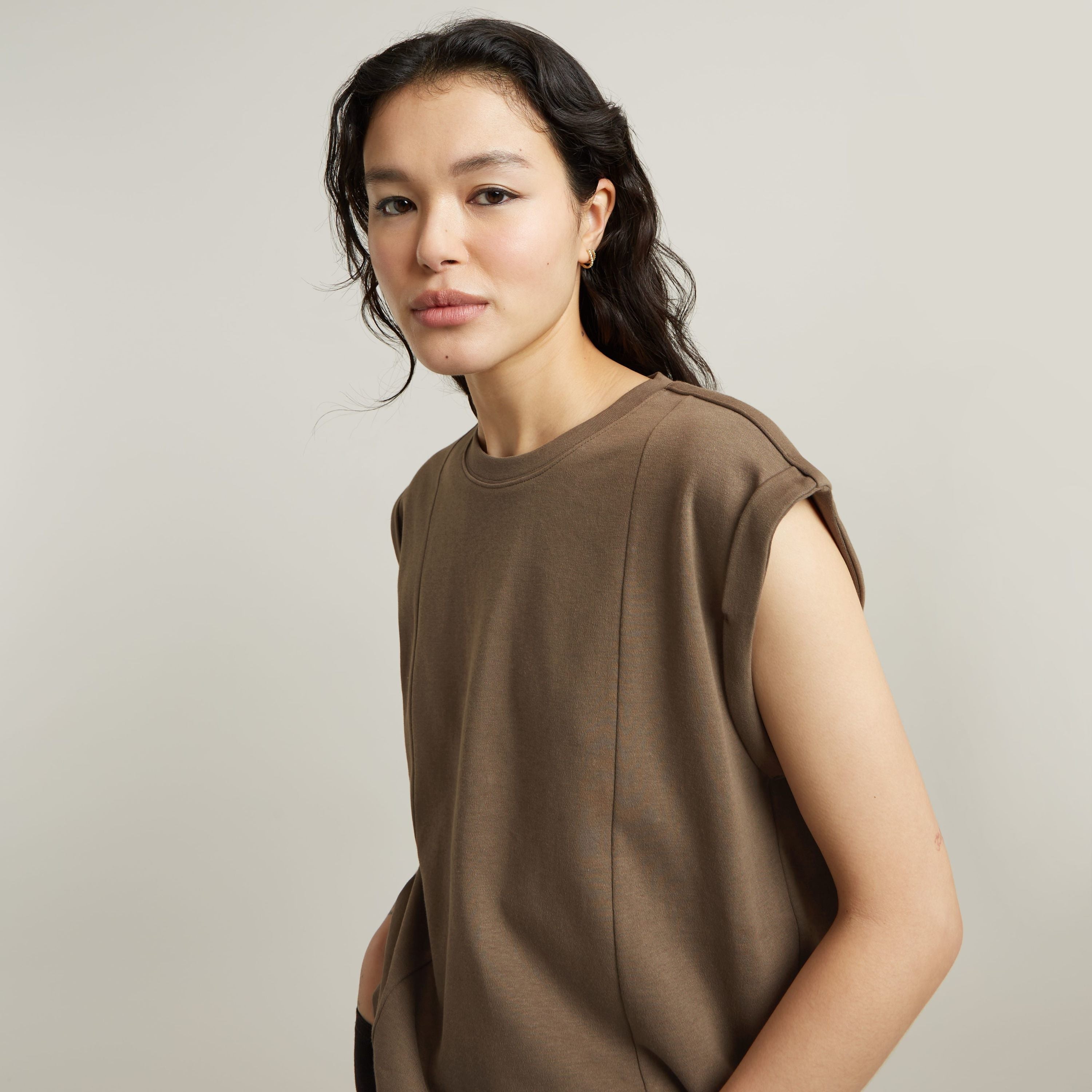 constructed loose top with short sleeves in brown worn by a model on a neutral background