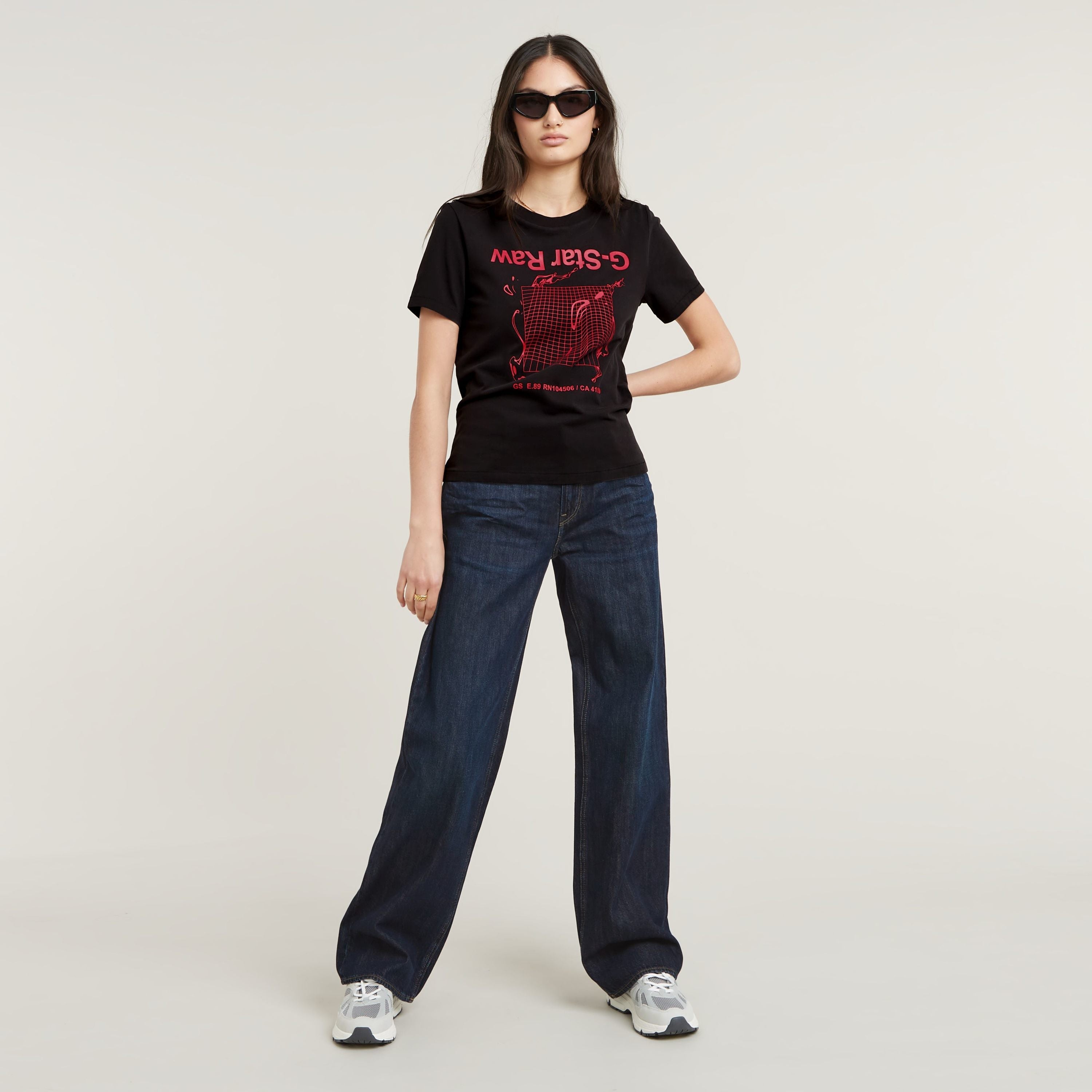Mujer con camiseta gráfica Gstar ecológica de corte recto y pantalones vaqueros oscuros.
