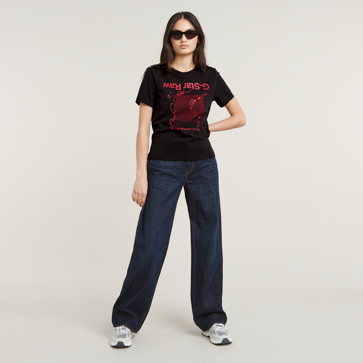 Mujer con camiseta gráfica Gstar ecológica de corte recto y pantalones vaqueros oscuros.