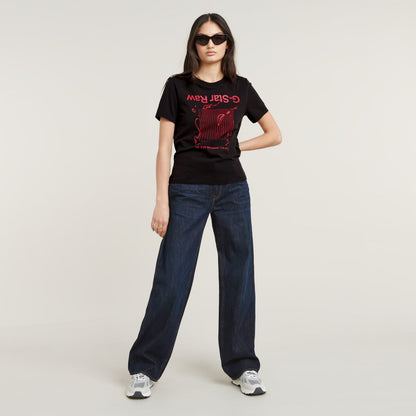 Mujer con camiseta gráfica Gstar ecológica de corte recto y pantalones vaqueros oscuros.